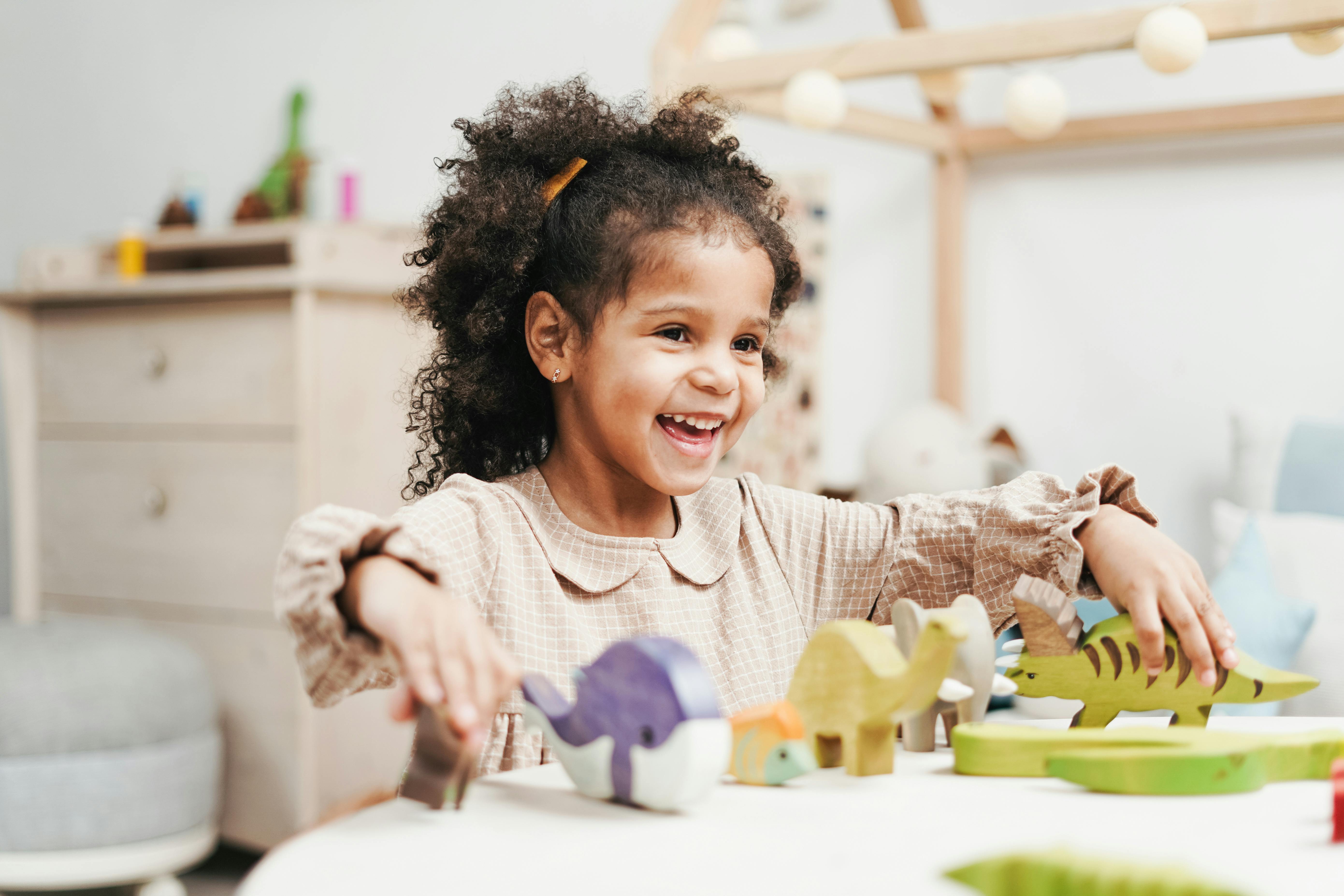 A joyful young girl playing with wooden toys, showcasing pure childhood happiness.